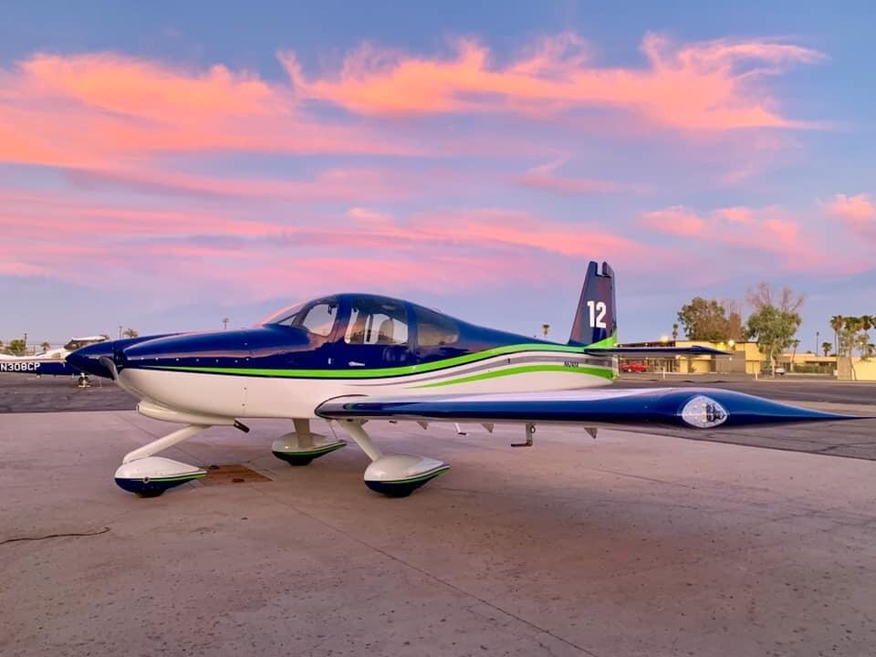 Cessna 172 single-engine trainer aircraft on hangar ramp at sunset